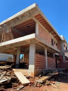 Casa em construção, com alvenaria e vigas de concreto aparentes