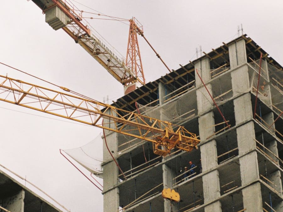 Canteiro de obra com duas gruas-torre e edifício em estrutura de concreto